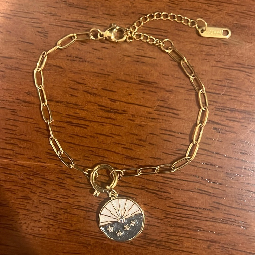 Gold toned moon and star‎ circular charm on paper clip charm bracelet